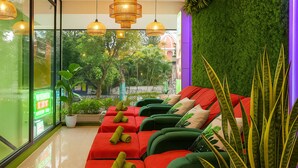 Ein moderner Lounge-Bereich mit grünen Sofas, roten Kissen und einer grünen Wand.