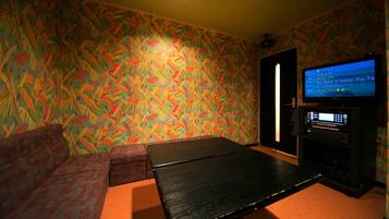 Una habitación con pared estampada, un sofá, una mesa y una televisión.