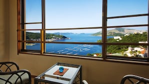 A room with a large window offering a view of a coastal area with boats and greenery. - Toba View Hotel Hanashinjyu (Toba)