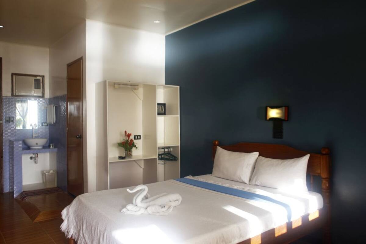 Une chambre d’hôtel avec un lit, une salle de bain et une armoire.