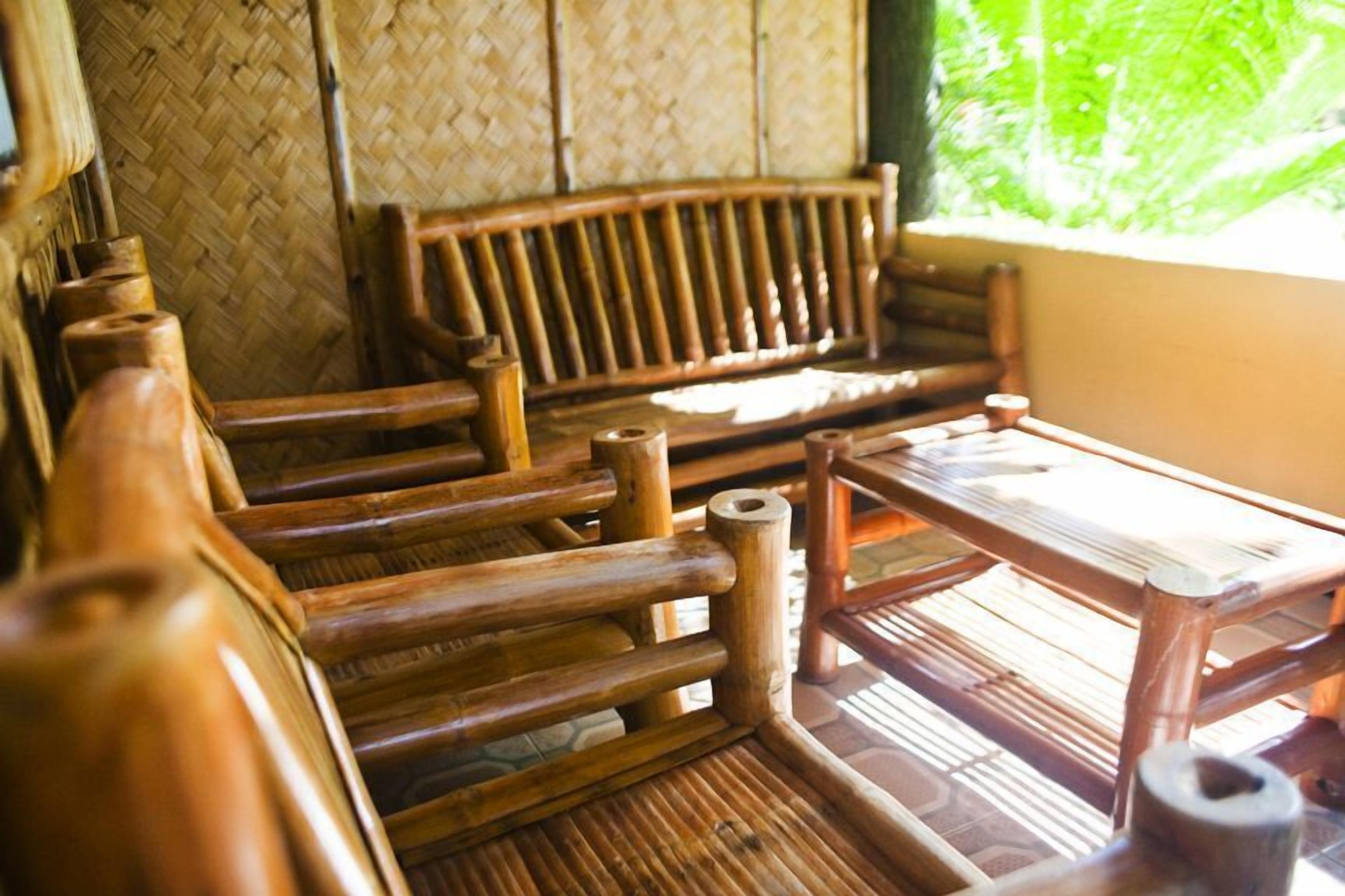 A traditional wooden bench and table in a room with woven bamboo walls.