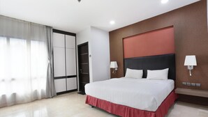 A modern hotel room with a large bed, a wardrobe, and a bathroom.