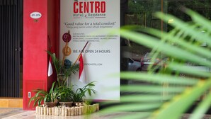 A hotel entrance with a sign listing amenities like a meeting room, BBQ restaurant, and swimming pool.