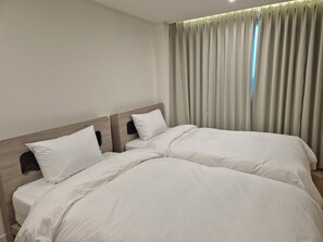 A double bed with white bedding in a hotel room. - Gwang Jang Hotel (Busan)