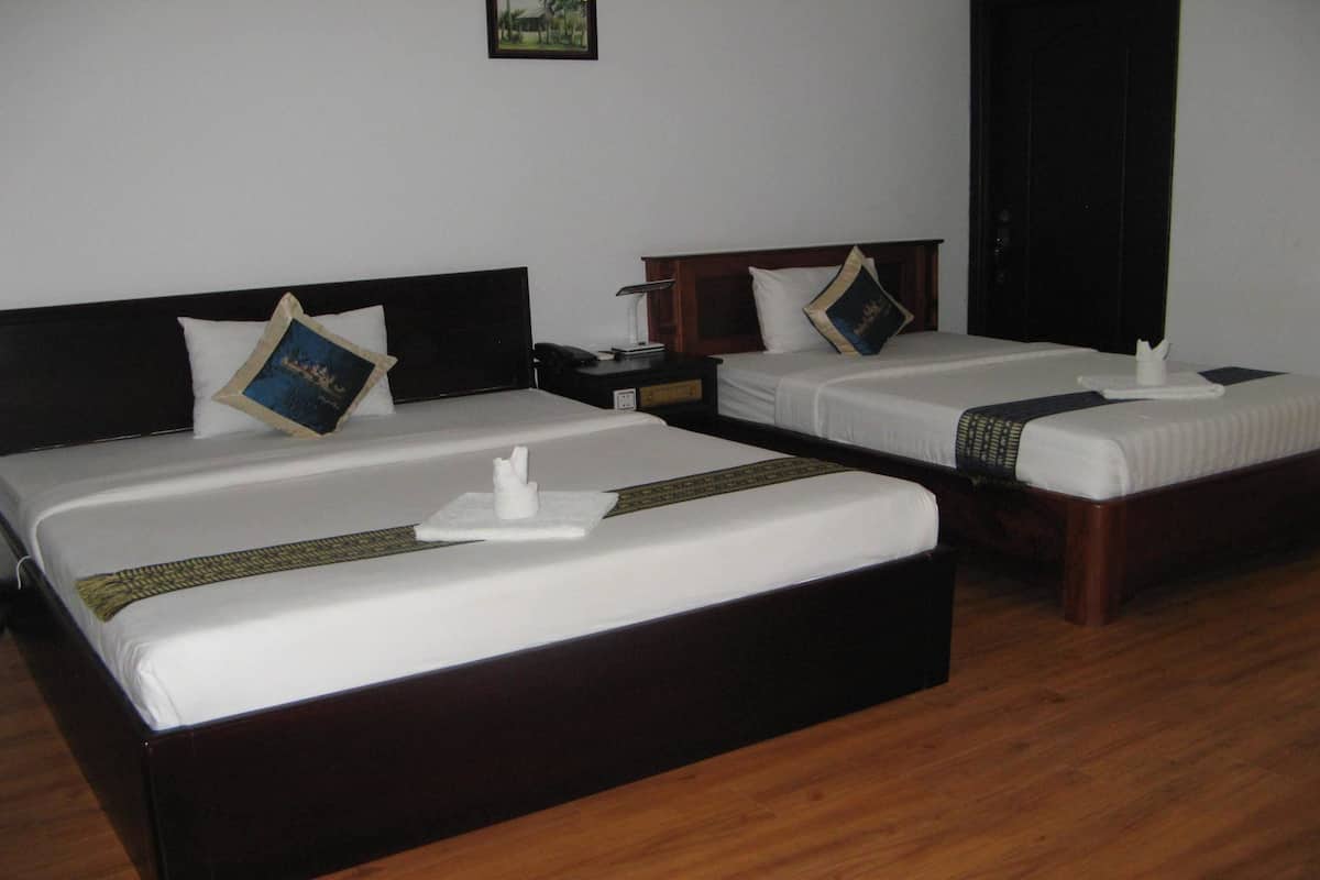 Dos camas dobles con cabeceros de madera, ropa de cama blanca y almohadas decorativas.