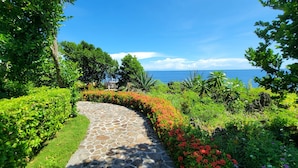 A stone pathway leading to a scenic view of the ocean. - Kawayan Holiday Resort (San Juan)