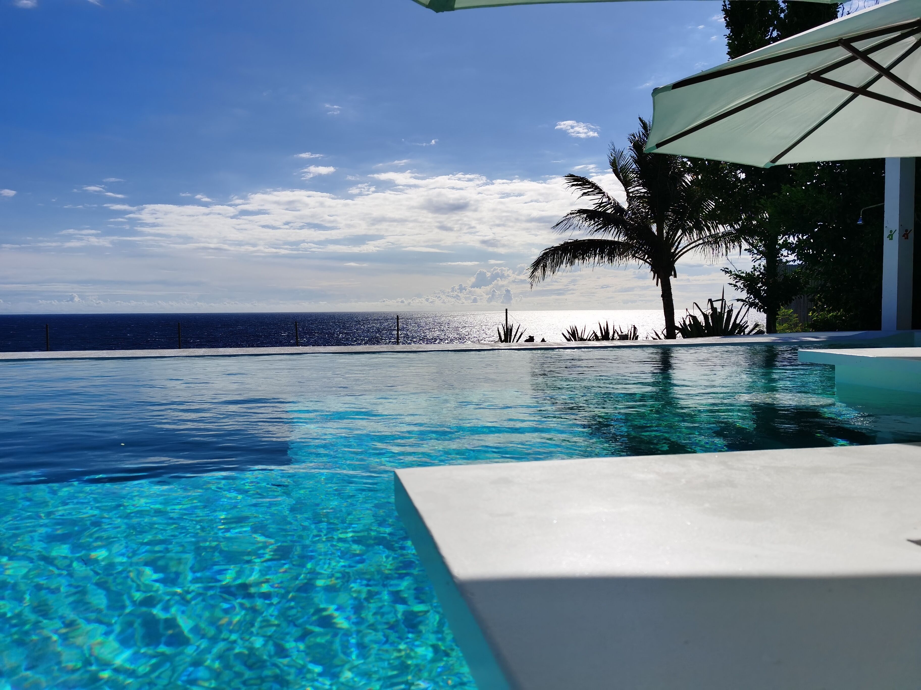 outdoor pool, an infinity pool, open 7:00 am to 6:00 pm, pool umbrellas