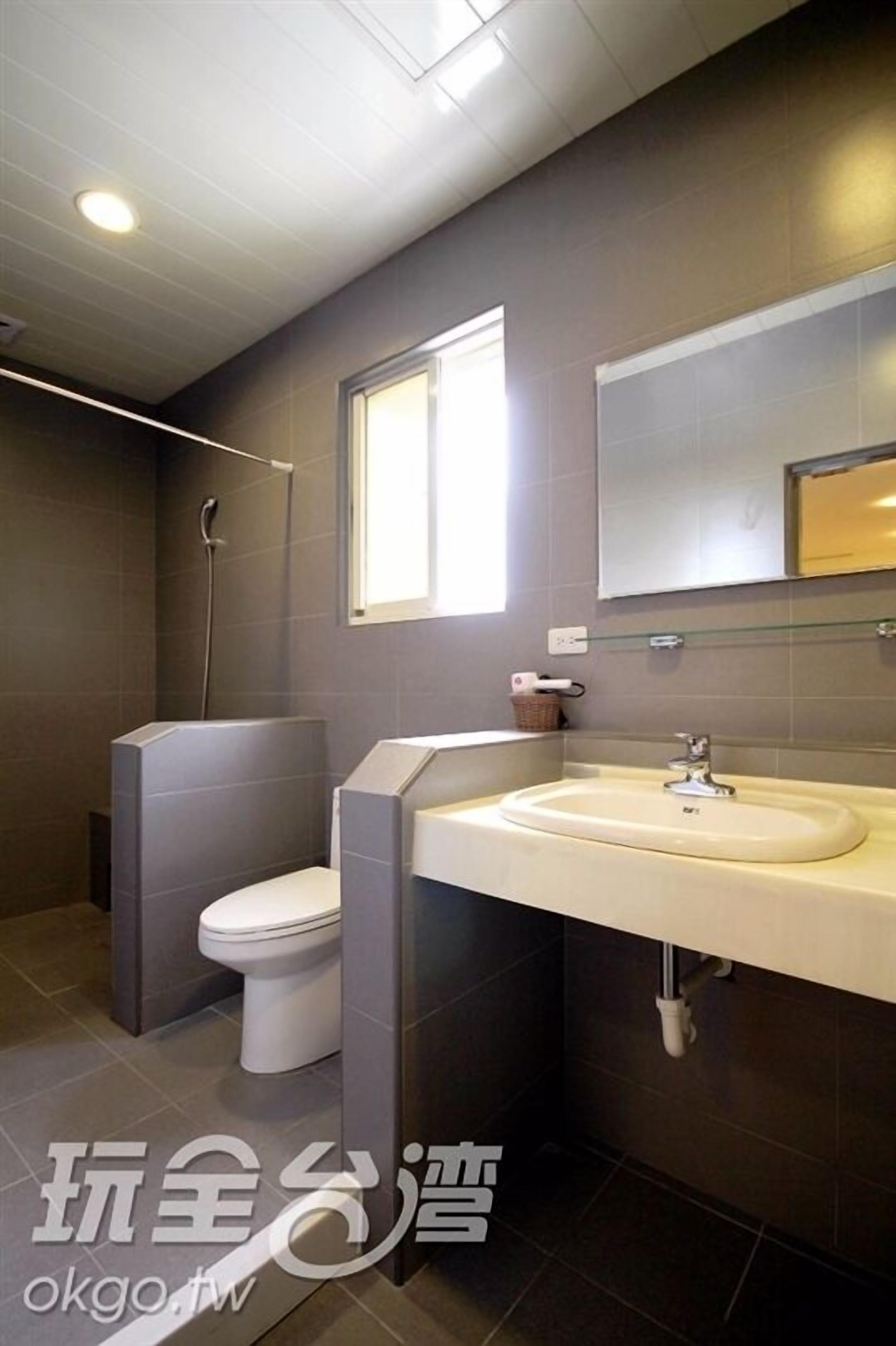 Een moderne badkamer met toilet, wastafel en douche.