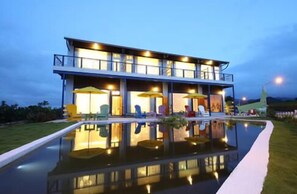 A modern two-story building with a swimming pool in front. - Follow Me B&B (Dongshan)