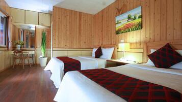 Una habitación de hotel con dos camas, paredes de madera, un cuadro, un escritorio y una silla.