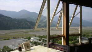 Una mesa con vista a un valle y montañas a través de amplios ventanales.