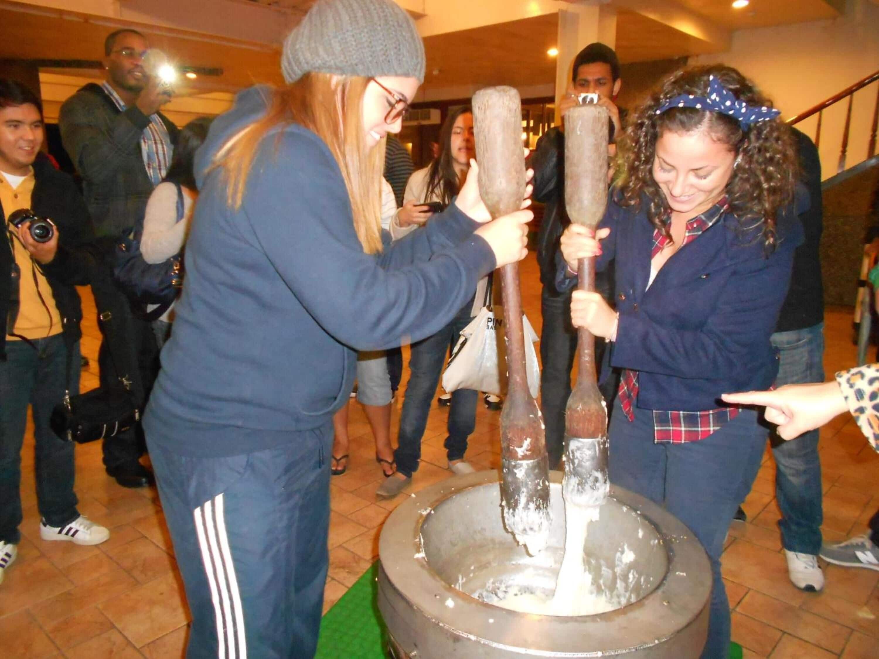 A group of people participating in a traditional activity involving large wooden vessels.