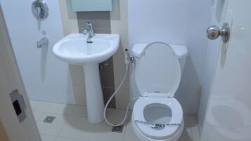 A bathroom with a white sink, toilet, and bidet.