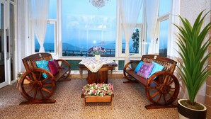 A sunlit room with a wooden bench, a table with a lace tablecloth, and a potted plant. - Yilan Yalu Good View Homestay (Datong)