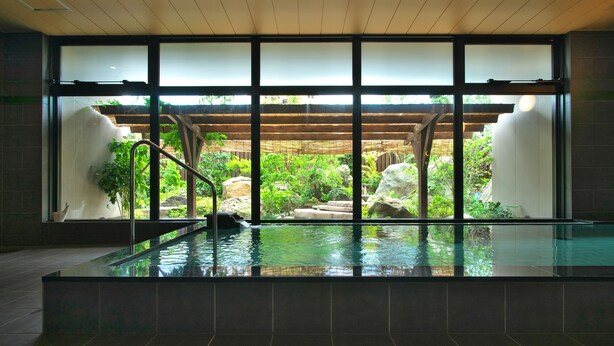 A modern indoor pool with a view of a lush garden through large windows. - The Kanazawa Sainoniwa Hotel (Kanazawa)
