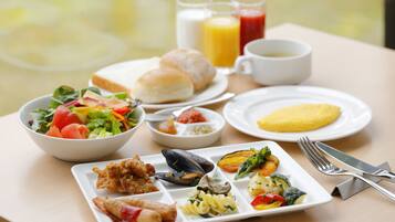 A table with a variety of breakfast items including eggs, bread, and a salad.