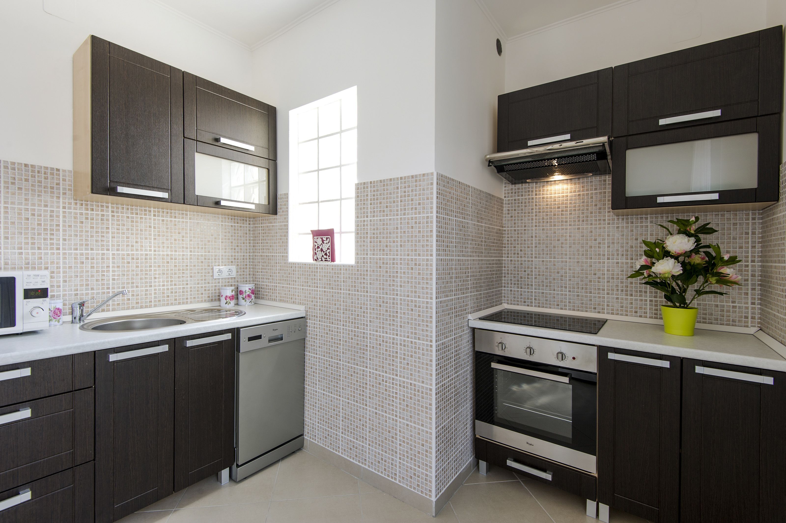 A modern kitchen with dark cabinets, a microwave, a dishwasher, and an oven.