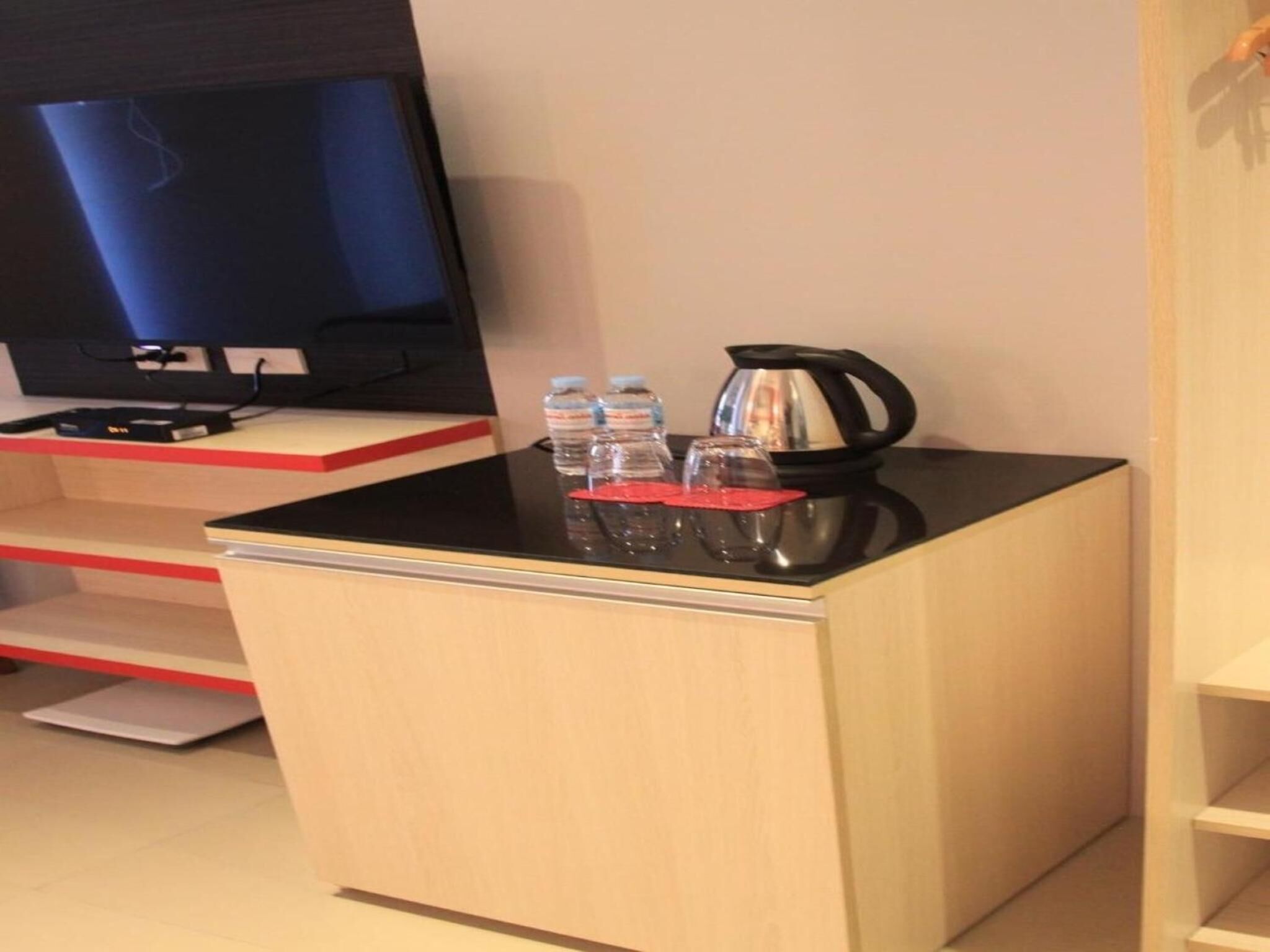 A small kitchenette with a black countertop, a kettle, and water bottles.