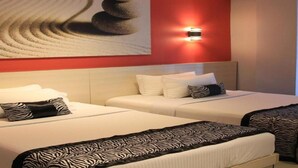 A hotel room with two beds, a red accent wall, a large abstract painting, and a wall-mounted light fixture. - Sumo Asia Hotels - Davao (Davao)