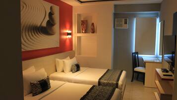 Una habitación de hotel con dos camas, un escritorio, una silla, un televisor y una obra de arte en la pared.