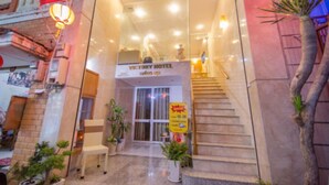 The exterior of Victory Hotel with a staircase leading to the entrance, a signboard, and potted plants. - Marie-Line Hotel (Ho Chi Minh City)
