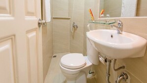A compact bathroom with a toilet, sink, and shower. - Marie-Line Hotel (Ho Chi Minh City)