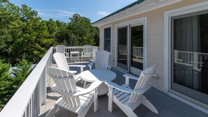A deck with white Adirondack chairs and a round table, surrounded by a white railing. - Inn-Seaclusion: Elevator, Private Pool & Hot Tub, Theater Room (Corolla)