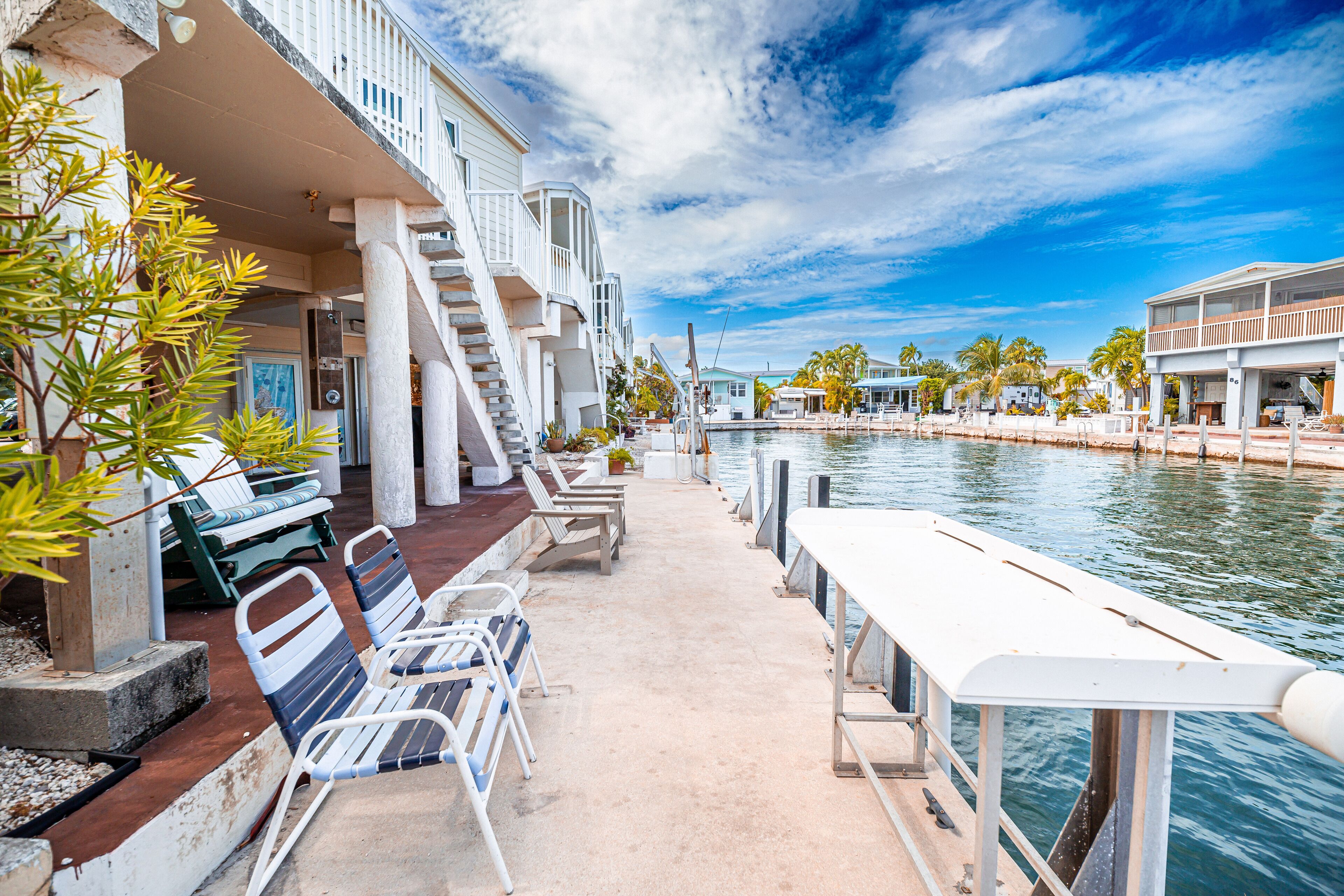 Une propriété située au bord de l’eau, dotée d’une terrasse couverte, d’un espace salon extérieur et offrant une vue sur l’eau.