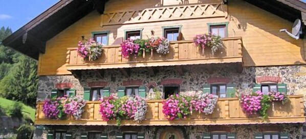 Traditional chalet with a balcony and steeply pitched roof, offering a charming alpine atmosphere.