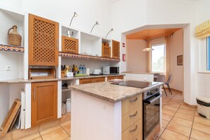 Une cuisine moderne avec des meubles en bois, un four Ă micro-ondes encastrĂ© et un grand Ăźlot central dotĂ© dâun Ă©vier.