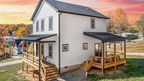 Et toetagers hus med en overdækket veranda og en terrasse.
