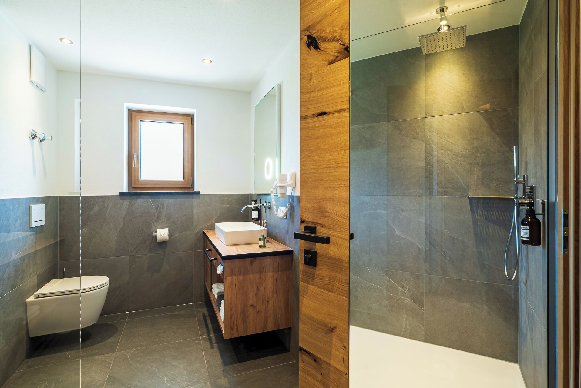Ein modernes Badezimmer mit Toilette, Waschbecken und Dusche.