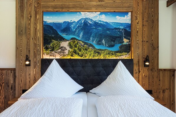 Relax in a serene space with a stunning mountain view, a comfortable bed, and a tufted headboard.