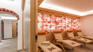 Ein Wellnessraum mit Holzstühlen, Fliesenboden und einer Wand mit rotem und weißem Muster.