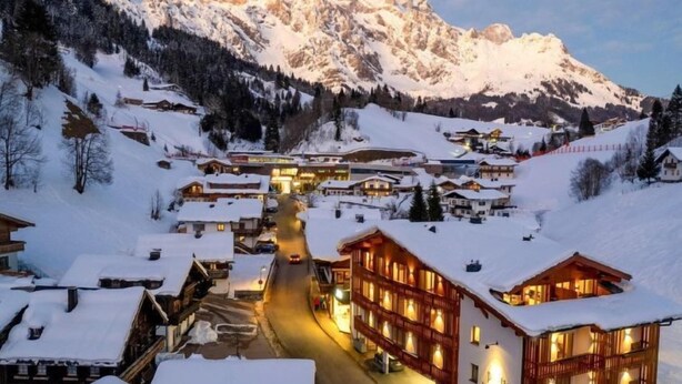 A snow-covered village with wooden buildings and a mountain backdrop. - 2 Raum Typ Klingspitz by Interhome (Dienten am Hochkönig)