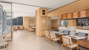A modern interior with a dining area, seating, and a kitchen. - Fairfield By Marriott Pujiang (Jinhua)