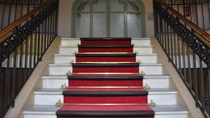 A staircase with white steps and red carpeted risers, flanked by black wrought iron railings. - Art Deco Studio in Font-Romeu with Pyrenees Views (Font-Romeu-Odeillo-Via)