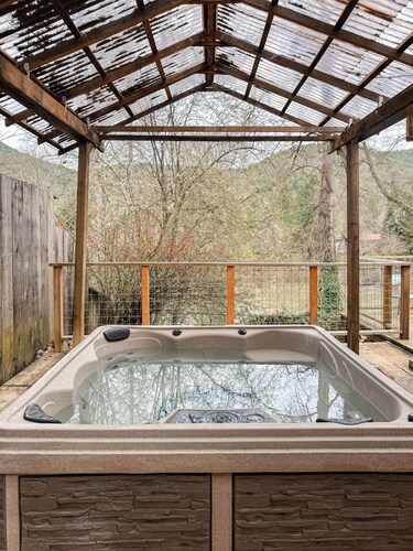 Charming 2-bedroom riverfront cottage! Enjoy a wood stove, W/D, and private hot tub overlooking the Rogue River. Perfect Gold Hill getaway for couples or a small family retreat.