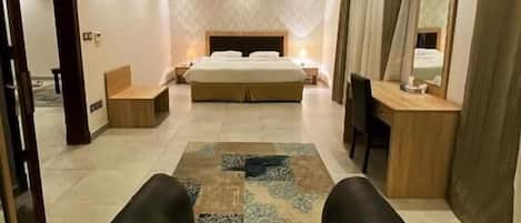 Una habitación de hotel moderna con una cama grande, un escritorio y una zona de estar.