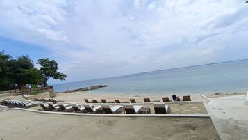 A beachside area with lounge chairs and a view of the sea.