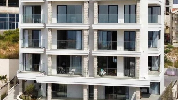 Un immeuble résidentiel à plusieurs étages, doté d’une architecture moderne, de grandes fenêtres et de balcons.