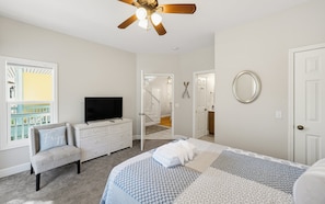 A bedroom with a bed, a dresser, a television, a ceiling fan, and a view of a balcony. - Resort Access & Golf Cart Included! (Fripp Island)