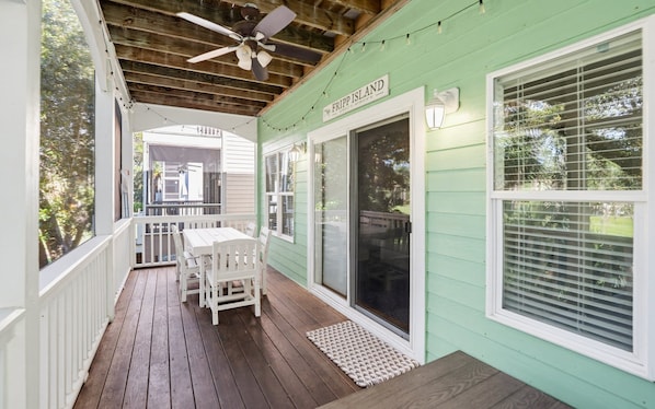 A covered porch with a ceiling fan, a table and chairs, and a sign that reads 'FRIPP ISLAND.' - Resort Access & Golf Cart Included! (Fripp Island)