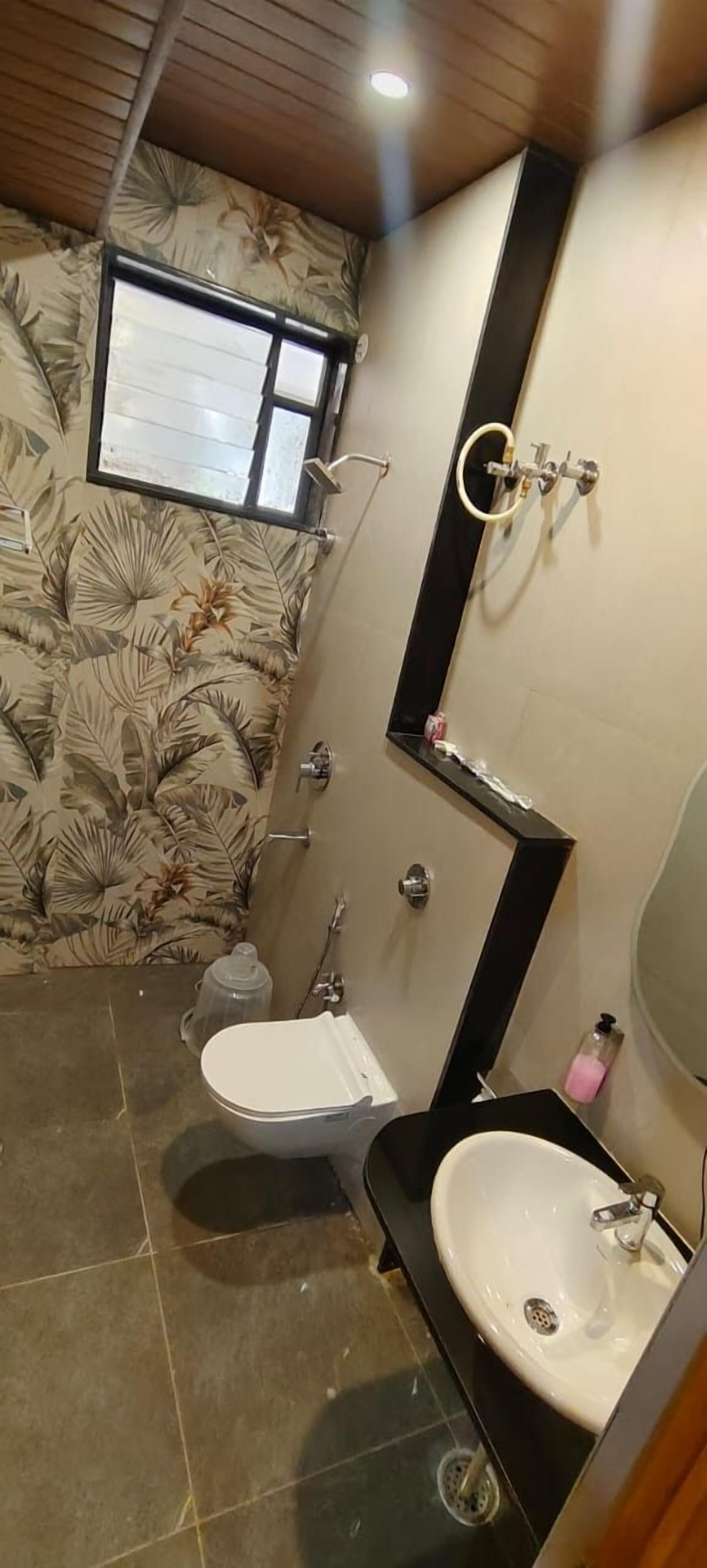 Un baño con inodoro, lavabo y ducha.