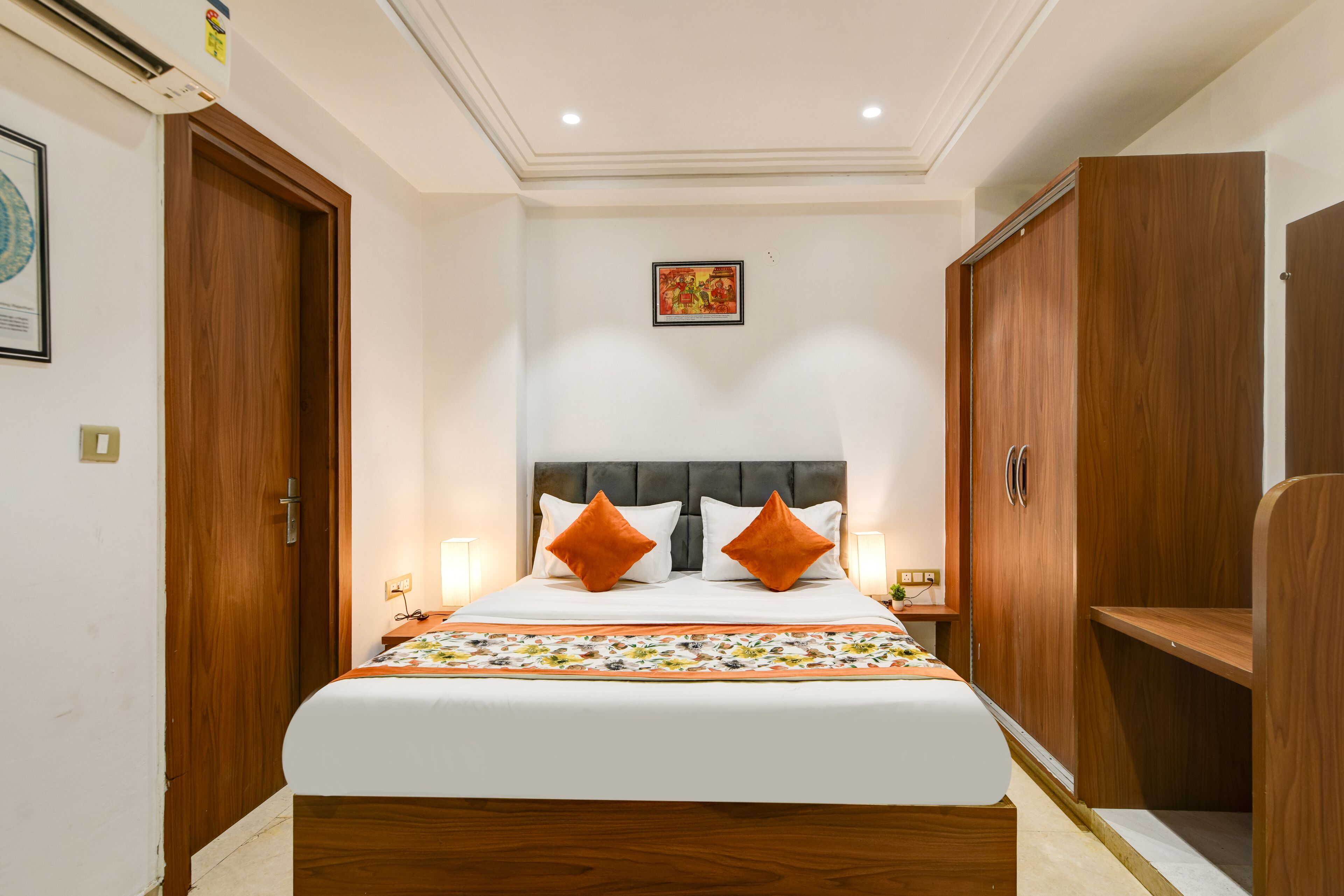 Una camera da letto ordinata con un letto grande, un'armadio in legno e un quadro appeso al muro.