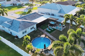 A residential property with a swimming pool, a hot tub, and a covered patio area. - Hot Tub, Pool & Putting Green: Cape Coral Oasis! (Cape Coral)