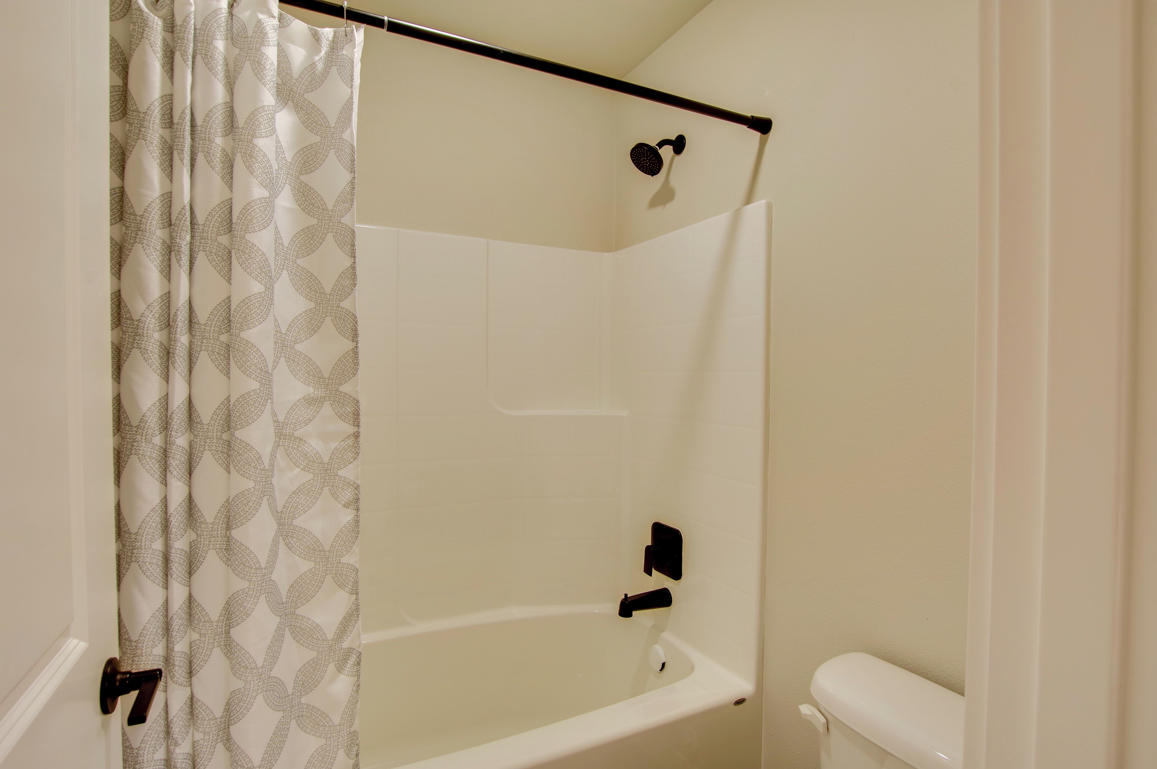 Ein Badezimmer mit Dusche, Toilette und Handtuchhalter.