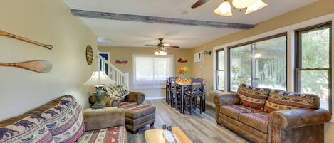 A spacious living room with a large sofa, a wooden coffee table, and a ceiling fan.