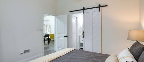 A bedroom with a bed, a sliding door, a ceiling fan, and a lamp.