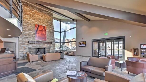 A spacious lobby with a stone fireplace, comfortable seating, a reception desk, and large windows offering views of the surrounding area. - Ultimate Park City Studio w/ Pool & Hot Tub! (Park City)